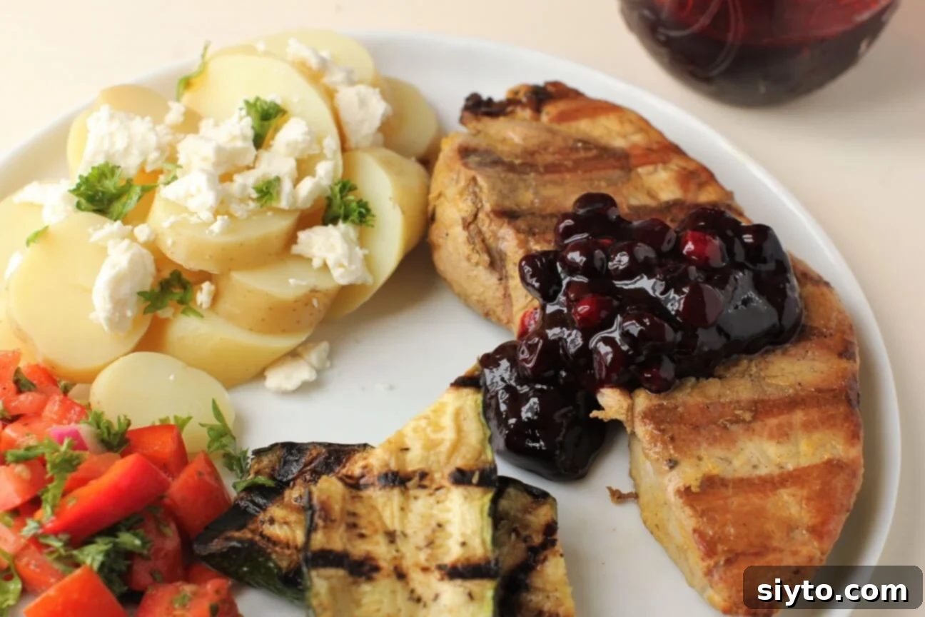 a dollop of saskatoon pickle on a grilled pork steak with sides