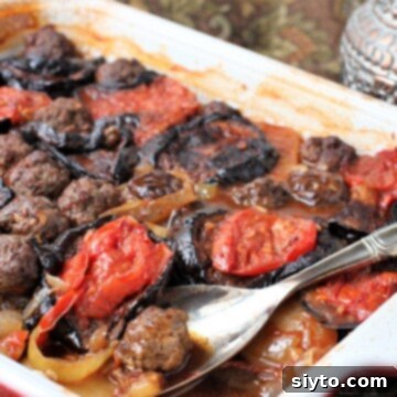 Iraqi comfort food dish - tepsi baytinijan is layers of eggplant, potatoes, tomatoes and meatballs