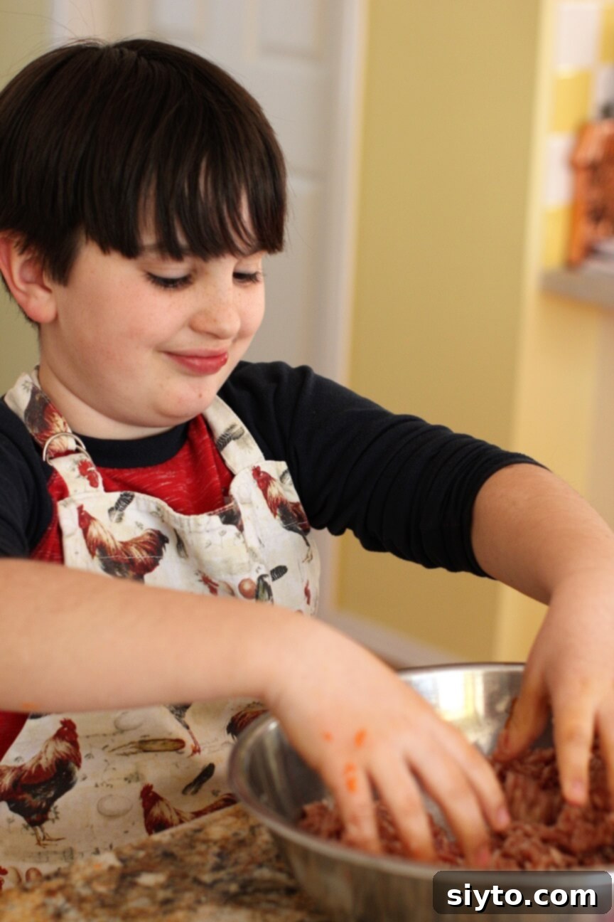 A child's hands mixing ground meat with salt and baking soda for homemade sausage patties.