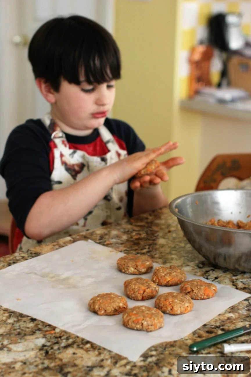 A child's hands, William's, skillfully rolling and shaping small, cute homemade sausage patties on a cutting board.