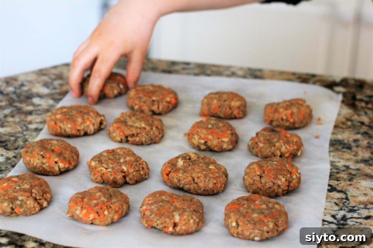 A neatly arranged batch of 16 cute, uncooked homemade sausage patties, ready to be cooked, showcasing their uniform size.