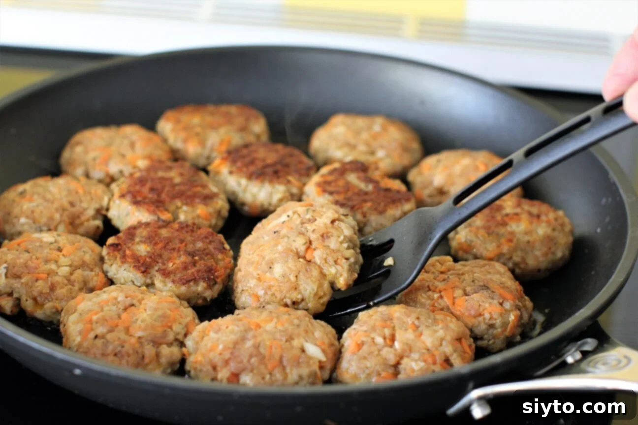 A skillet full of homemade sausage patties sizzling and frying until golden brown, showcasing their delicious appearance.