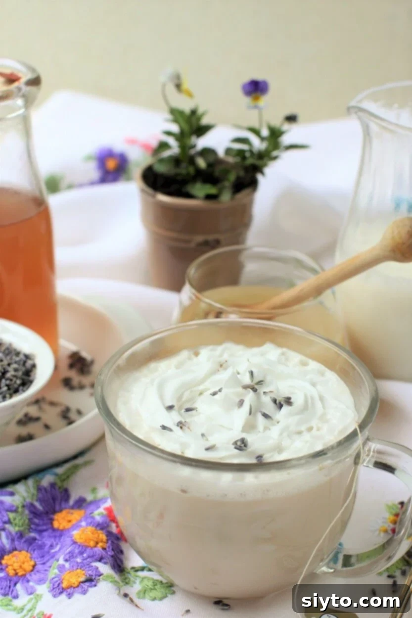 a lovely glass mug of Lavender London Fog Latte with coconut whip and lavender flowers