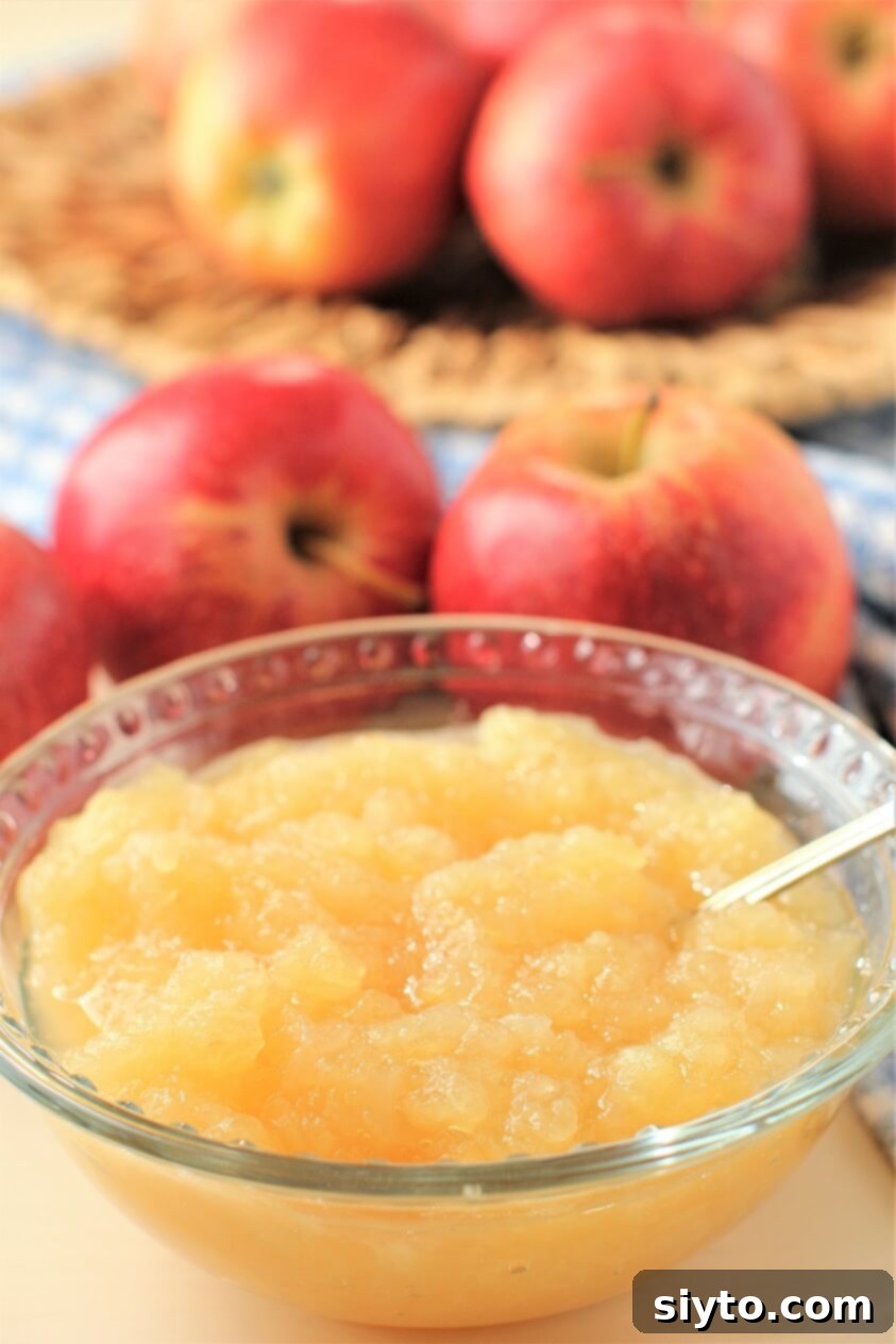 Instant Pot Applesauce No Added Sugar Plus a Kiwi Twist 8 A lovely bowl of instant pot applesauce, with a background of fresh apples, highlighting its natural goodness.