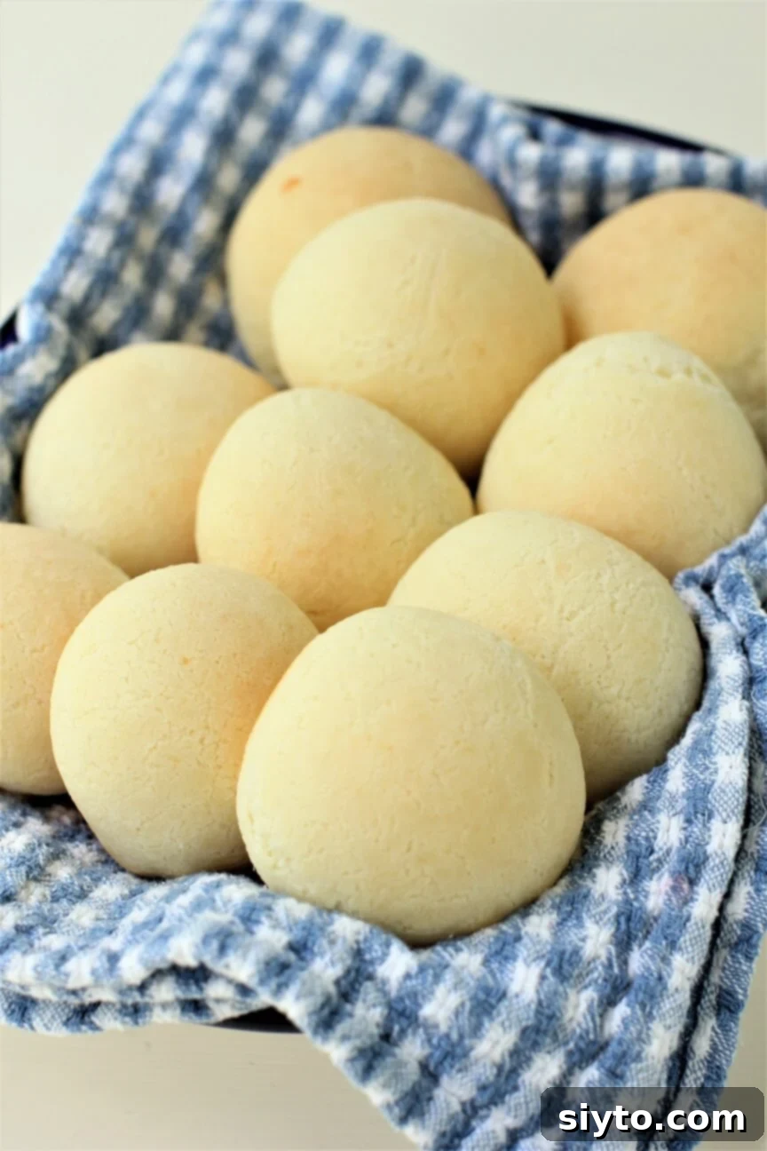 fresh pan de yuca cheese buns on a tea towel, showcasing their golden crust and inviting texture