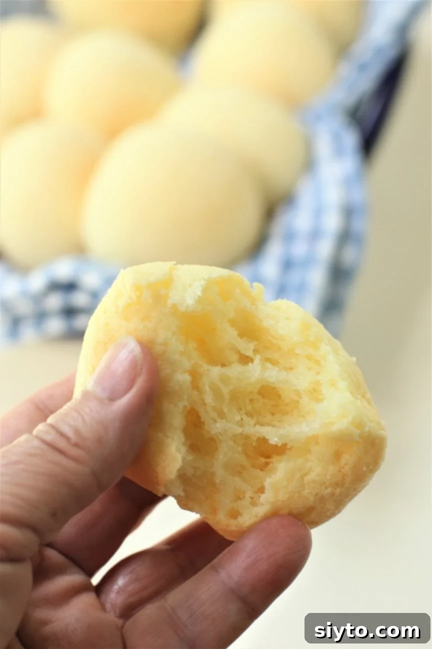 the inside of a cheesy pan de yuca pulled apart, revealing its warm, stretchy, and gooey texture
