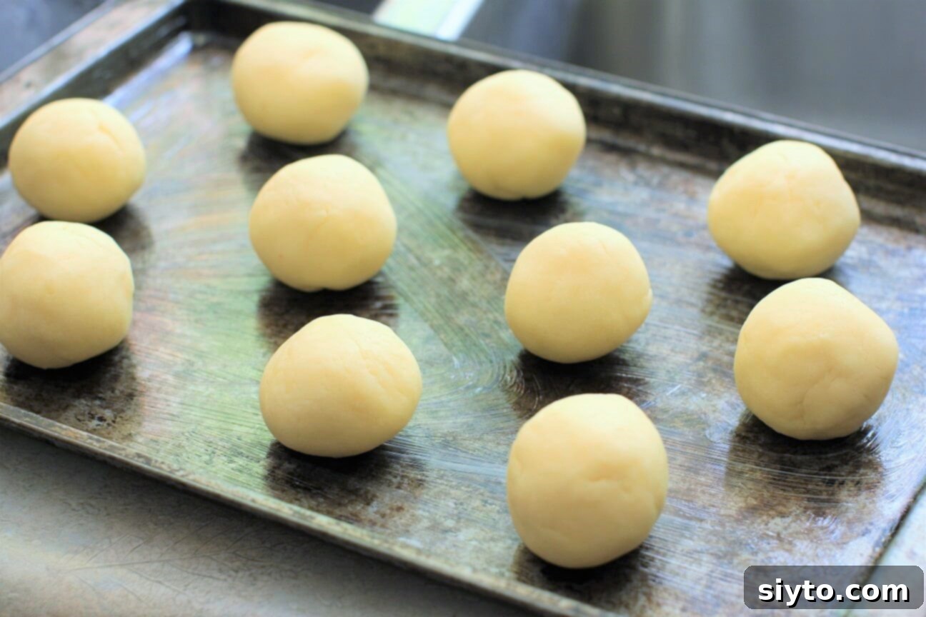 the pan de yuca dough rolled into perfect balls and neatly arranged on a greased baking sheet, ready for the oven