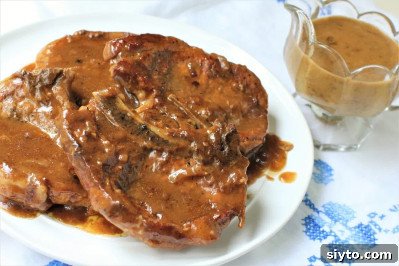 Southern Smothered Pork Chops: A Soul Food Classic 11 A serving plate piled high with tender smothered pork chops, accompanied by a side of rich, creamy gravy, a perfect representation of classic Soul Food comfort.
