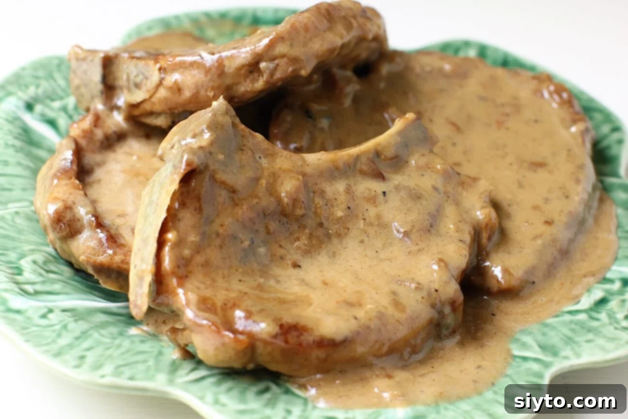 Southern Smothered Pork Chops: A Soul Food Classic 3 Close-up of tender smothered pork chops swimming in a rich, creamy gravy, a true Soul Food indulgence.