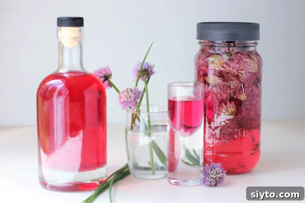 A beautifully illuminated bottle of chive blossom vinegar, showcasing its vibrant pink hue