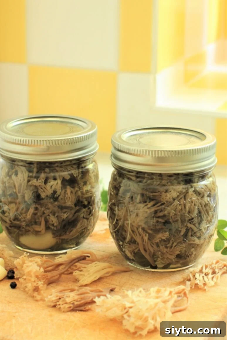 Two small glass jars filled with preserved coral mushrooms sit on a rustic wooden surface, showcasing their delicate, intricate forms suspended in a clear pickling brine.