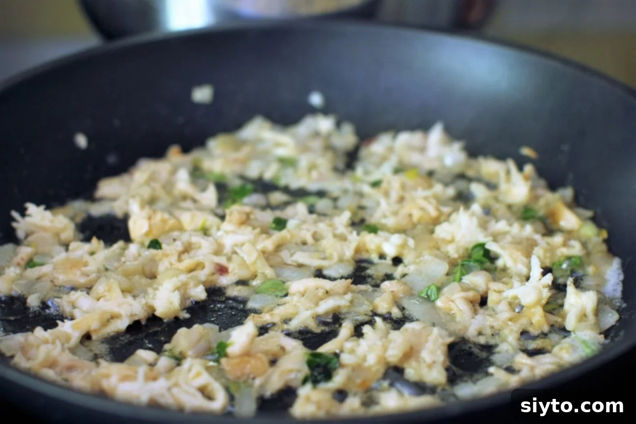 A close-up shot of chopped Hericium mushrooms gently sautéing in a skillet with melting butter, thinly sliced shallots, and fresh thyme sprigs, creating an aromatic and appetizing scene.