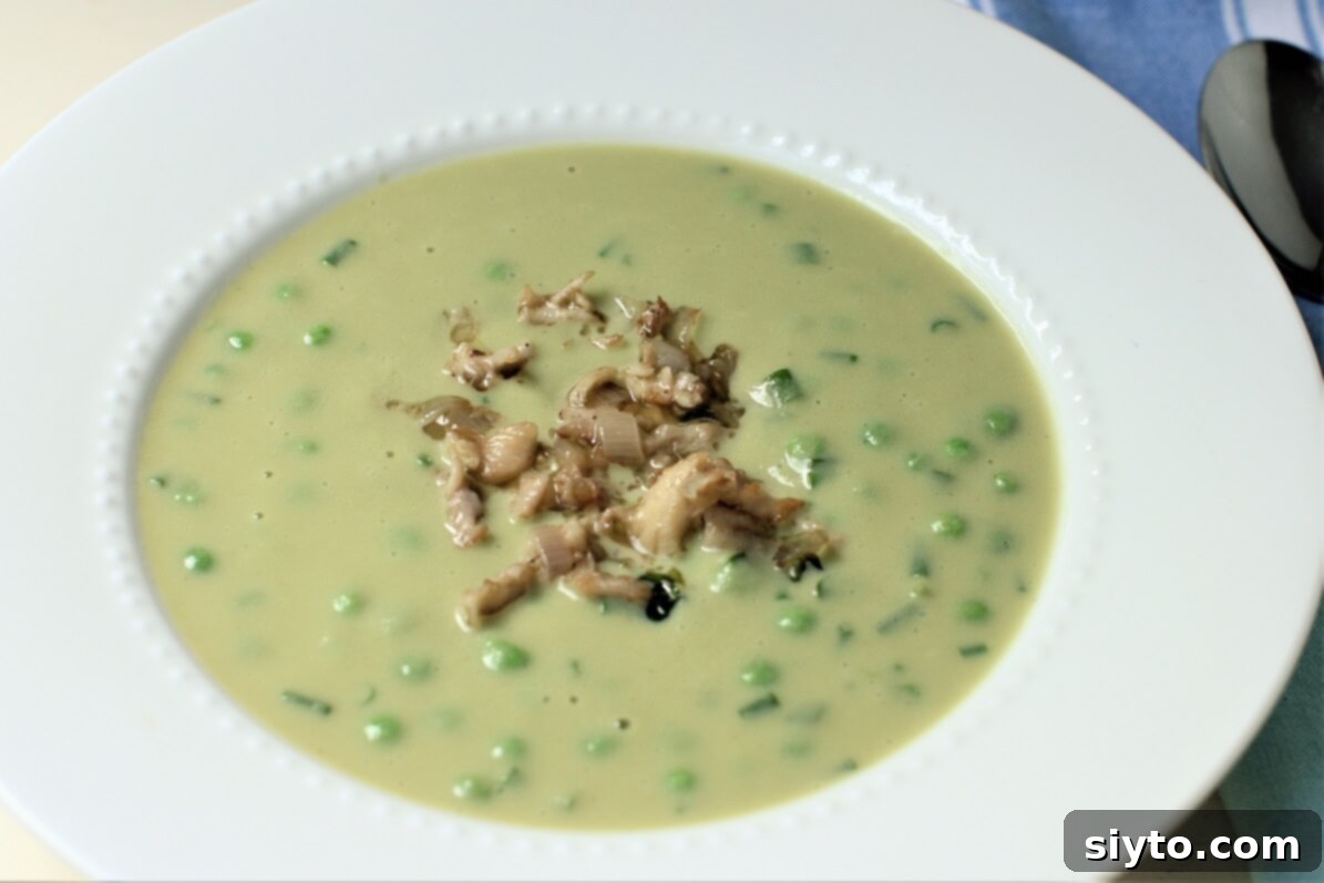 A bowl of creamy pea and lettuce soup elegantly garnished with delicate, sautéed Hericium mushrooms, highlighting their unique texture and presentation.