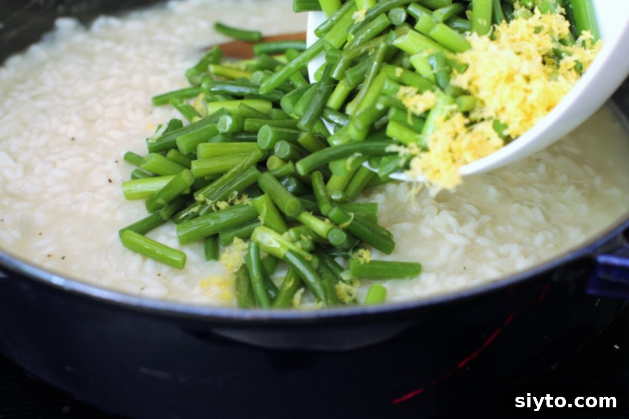 adding the garlic scapes and lemon zest to the risotto