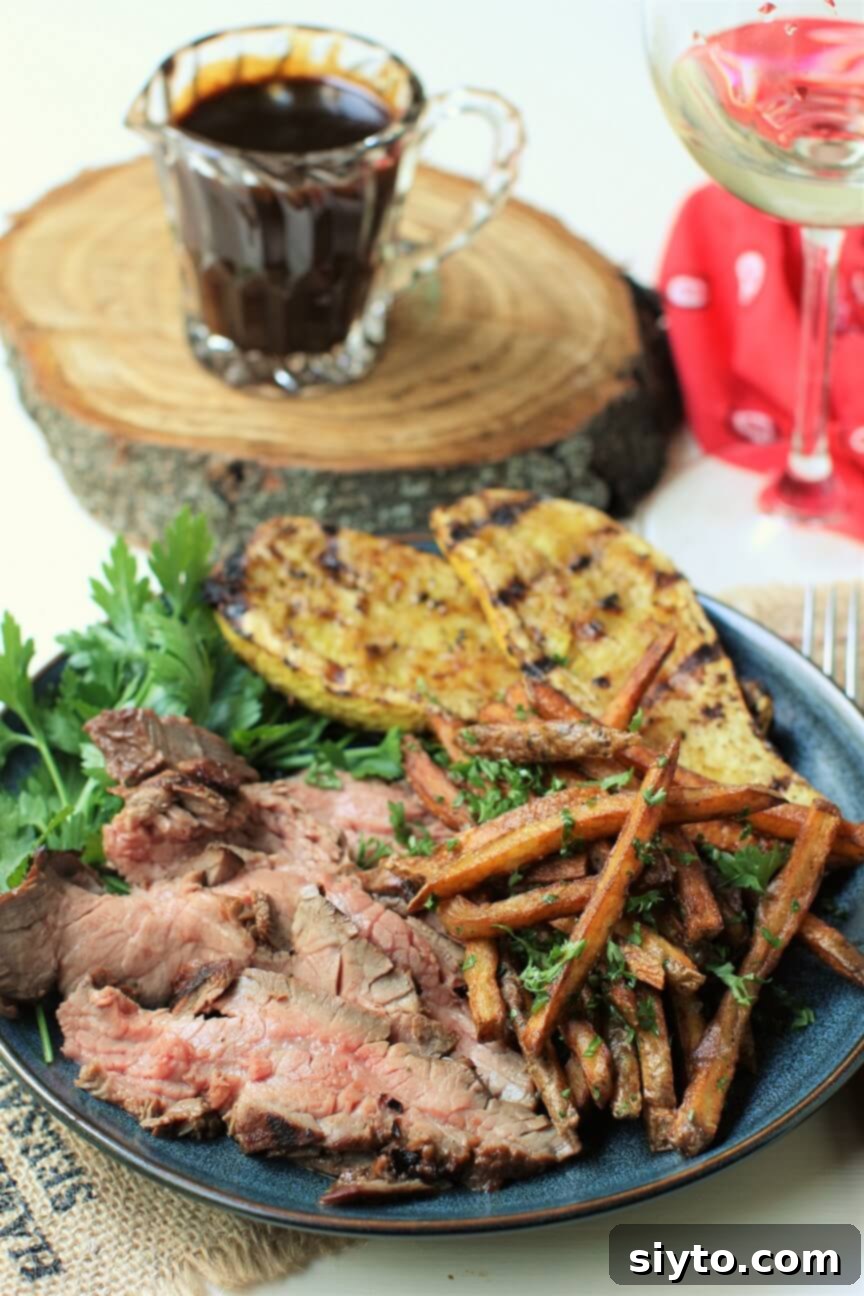 Banff's Best Bites Marinated Flank Steak and Mountain Views 2 Plate with perfectly grilled marinated flank steak, golden fries, tender zucchini, and a small pitcher of savory marinade sauce for drizzling