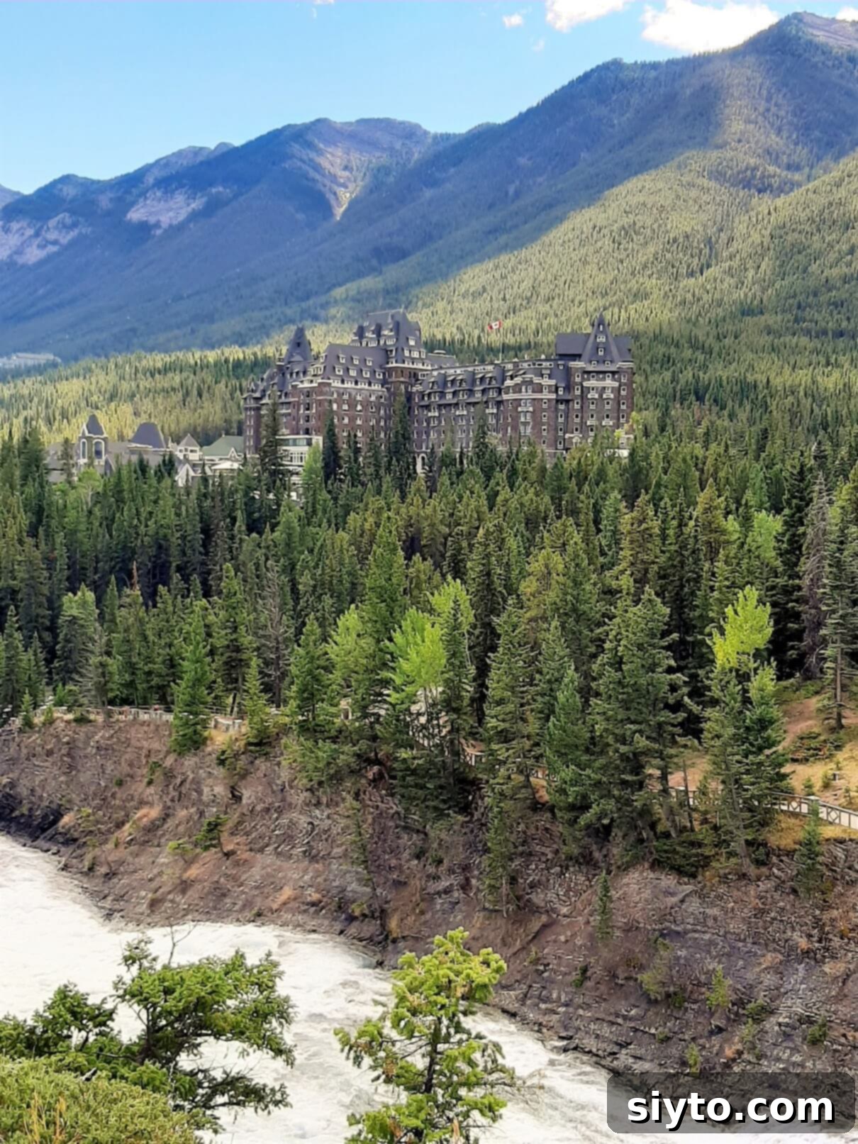 Banff's Best Bites Marinated Flank Steak and Mountain Views 13 The iconic Banff Springs Hotel, a majestic stone castle nestled amidst lush mountains under a clear sky
