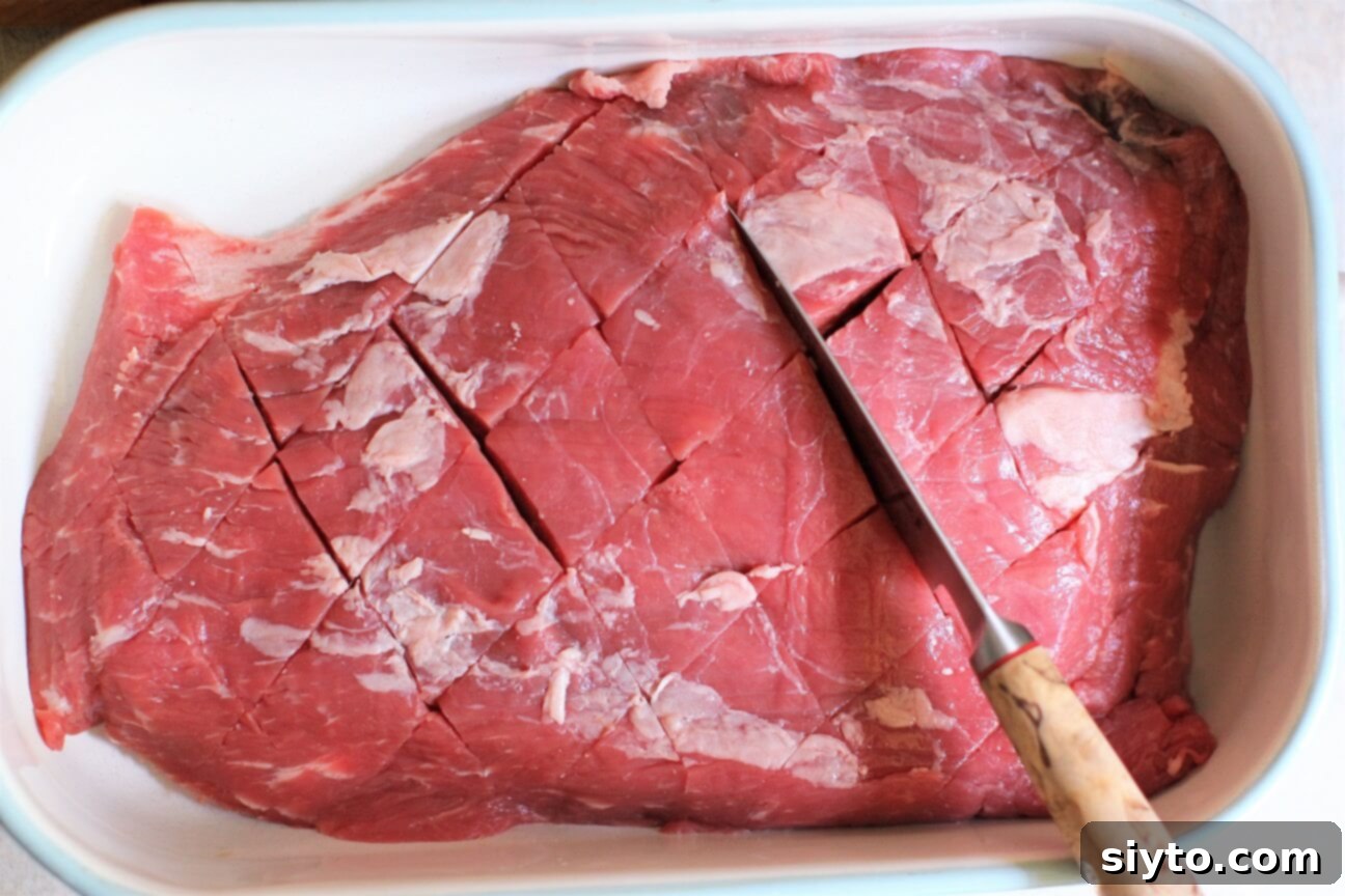 Banff's Best Bites Marinated Flank Steak and Mountain Views 3 Chef demonstrating how to crosshatch a flank steak with a knife to prepare it for marinating and grilling