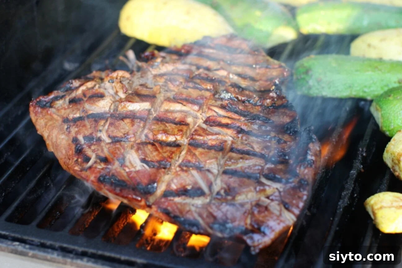 Banff's Best Bites Marinated Flank Steak and Mountain Views 6 Marinated flank steak cooking on a hot grill, surrounded by flames and smoke, with zucchini grilling alongside