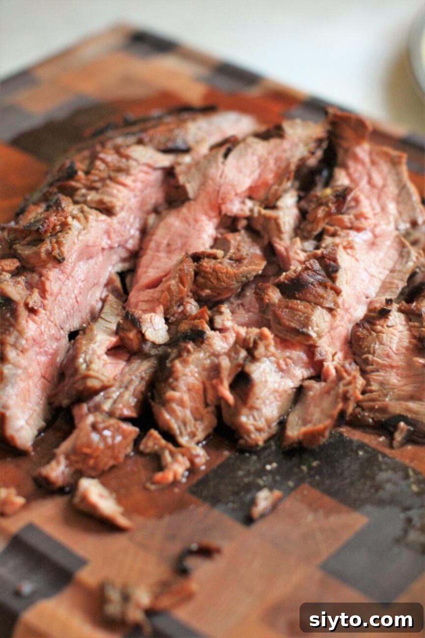 Banff's Best Bites Marinated Flank Steak and Mountain Views 8 Close-up of perfectly sliced grilled marinated flank steak on a cutting board, showing beautiful pink interior and juicy texture