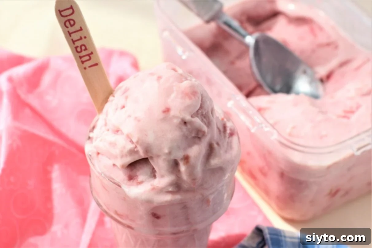 close up of cup of rhubarb ice cream, and freezer container behind