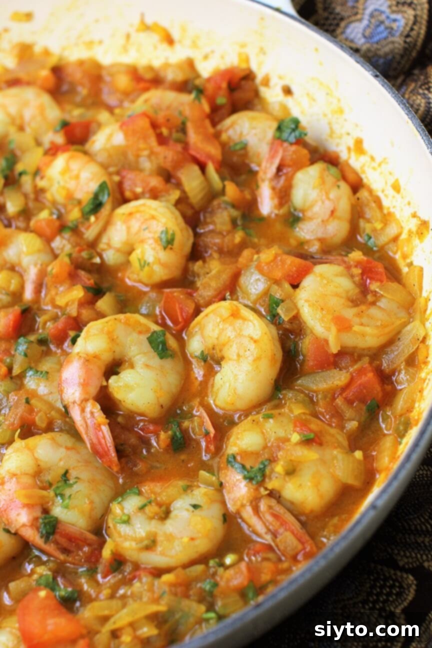 pan of shrimp curry (chingri masala) with vibrant colors