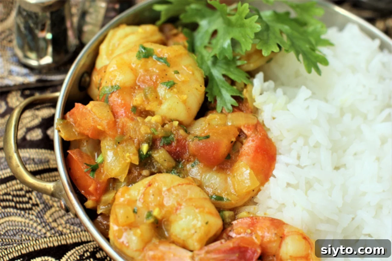 a bowl of Bangladeshi shrimp curry served with rice and cilantro garnish