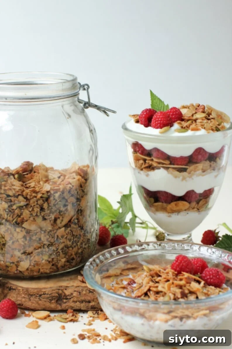 A layered yogurt parfait featuring homemade light and crispy granola, fresh berries, and creamy yogurt, perfect for a healthy breakfast or snack. You can also enjoy the granola simply with milk in a bowl.