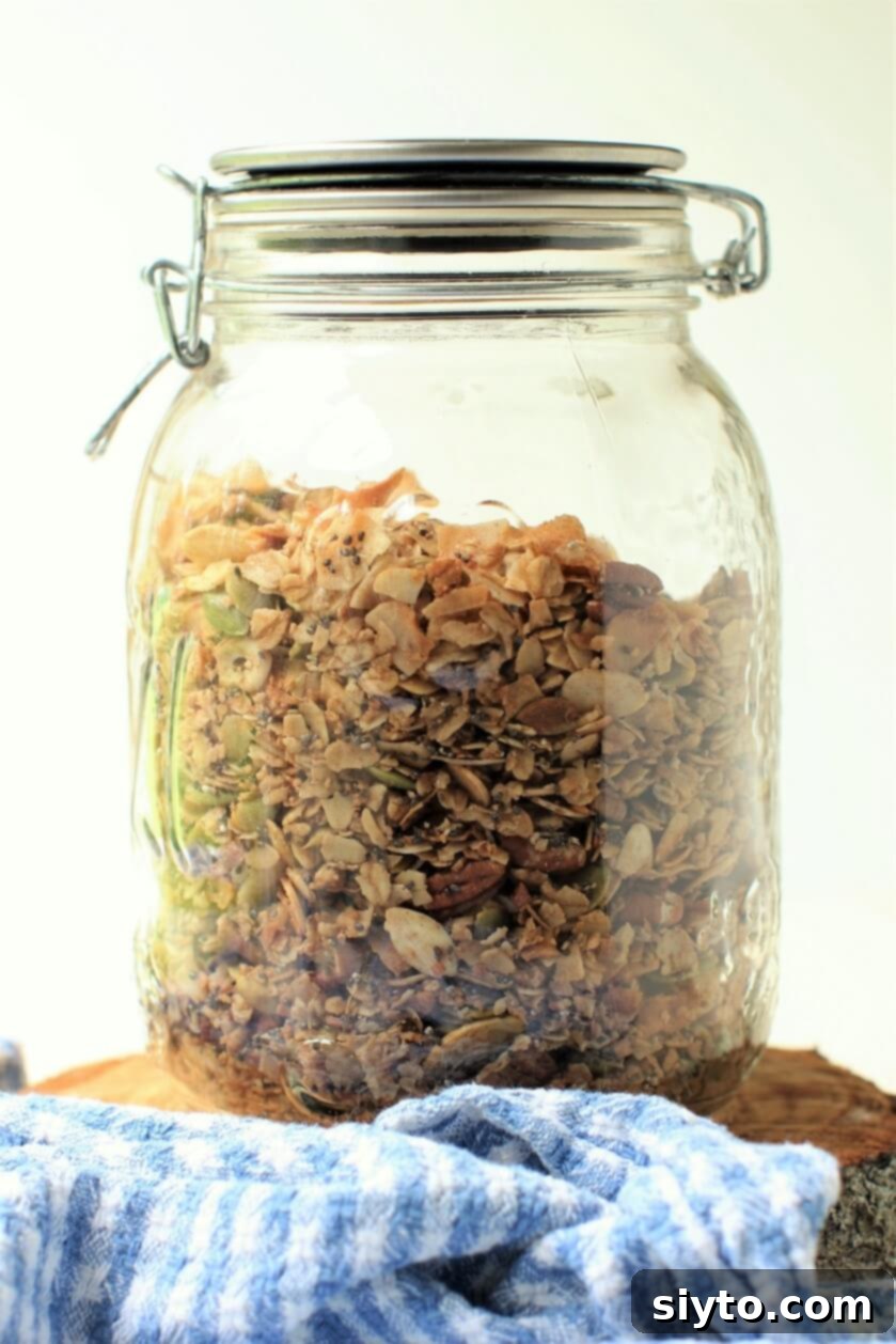 A rustic glass jar filled to the brim with golden, extra crispy homemade granola, ready for serving or storage.