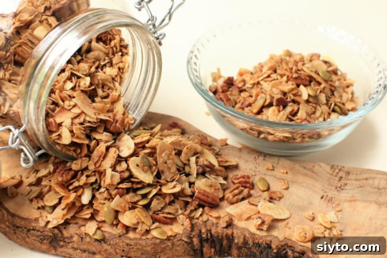 A stream of homemade light and crispy granola tumbling out of a glass jar onto a wooden cutting board, highlighting its appealing texture.