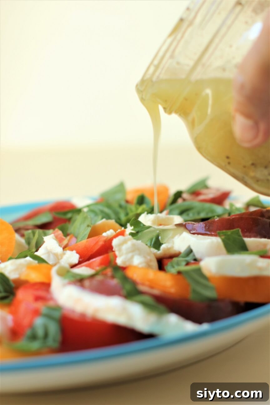 pouring the dressing onto the Heirloom Tomato Salad
