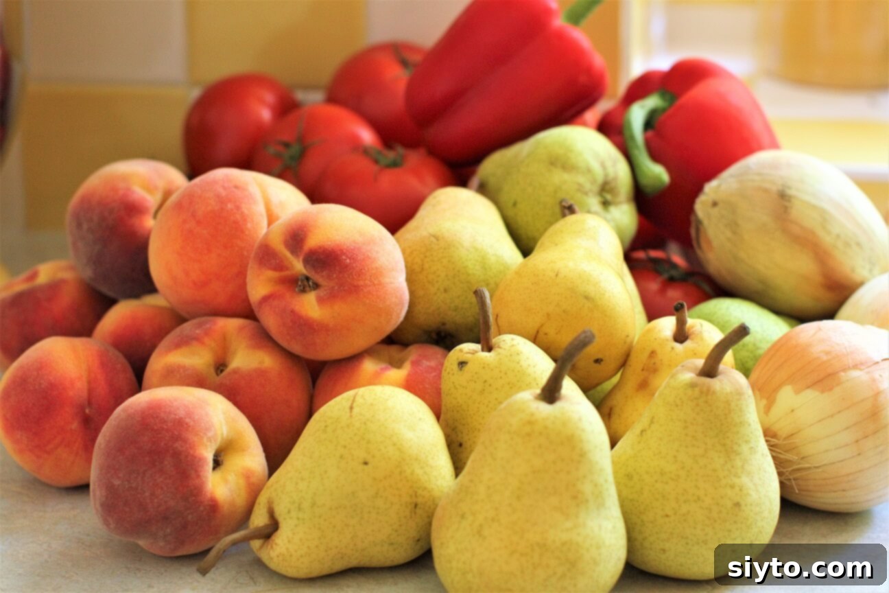 a pile of fresh pears, peaches, tomatoes, peppers, and onions