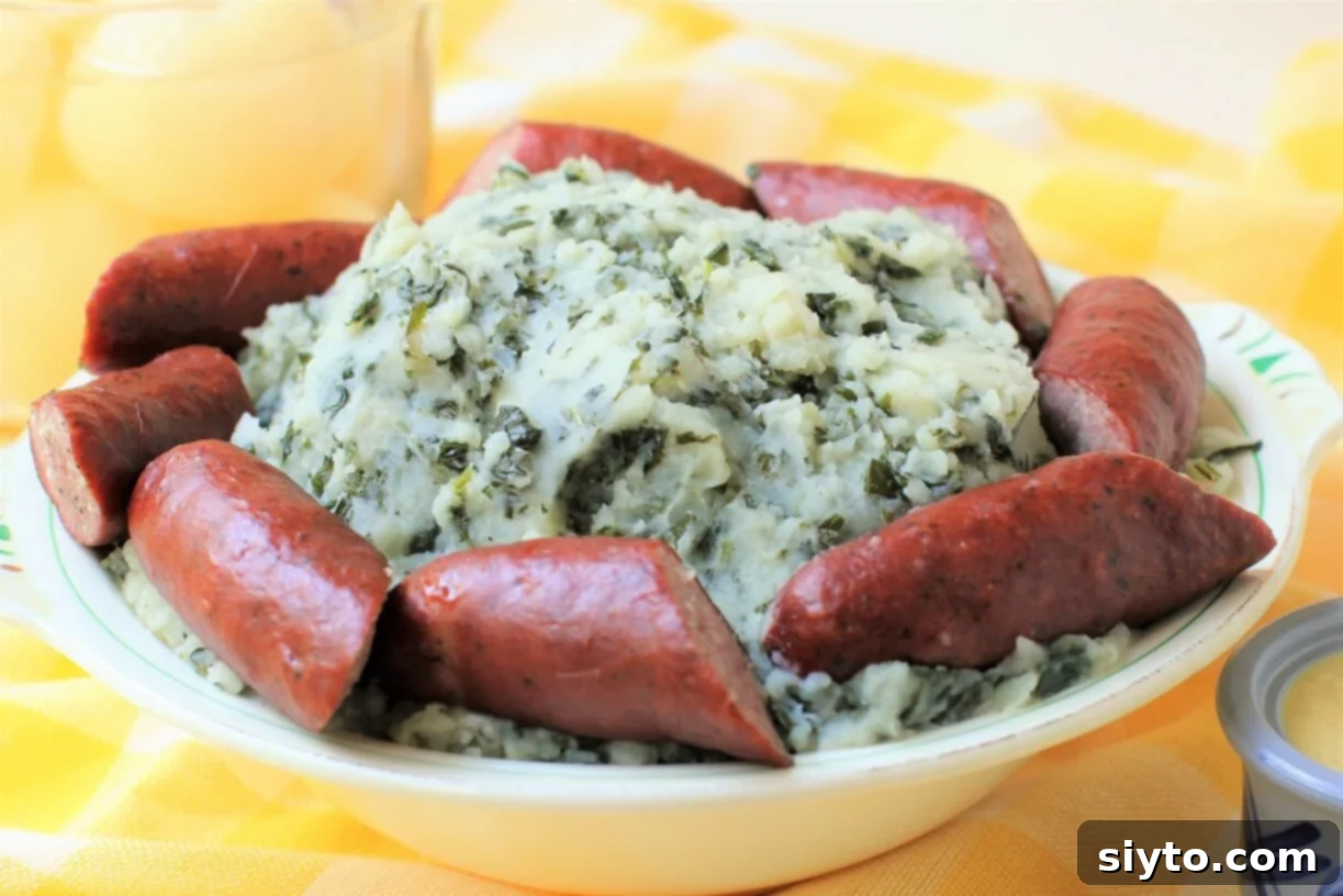 Boerenkool Stamppot The Heart of Dutch Comfort Food 3 A rustic bowl brimming with freshly prepared Boerenkool Stamppot, showcasing its vibrant green kale flecks within creamy mashed potatoes. Surrounding the bowl are savory smoked sausages, ready to be served.