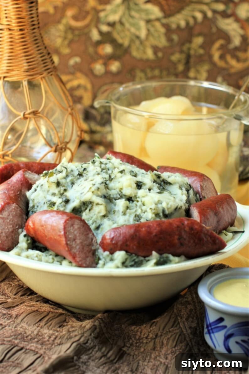 Boerenkool Stamppot The Heart of Dutch Comfort Food 4 A rustic table spread featuring a generous bowl of Boerenkool Stamppot with smoked sausages, a separate bowl of sweet canned pears, and a pot of mustard. The dark fabric background adds to the cozy, comfort food aesthetic.