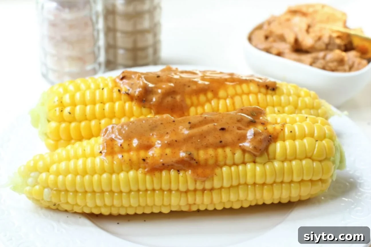 two cobs of corn with chili butter melting on them