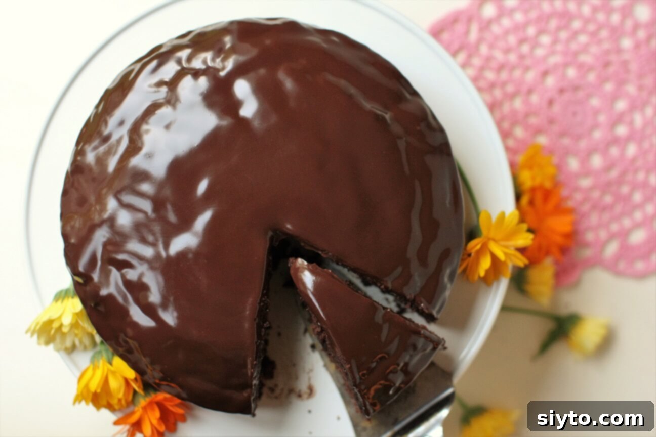 A top-down view looking directly onto the beautifully glazed Chocolate Zucchini Cake, showcasing its smooth, reflective surface
