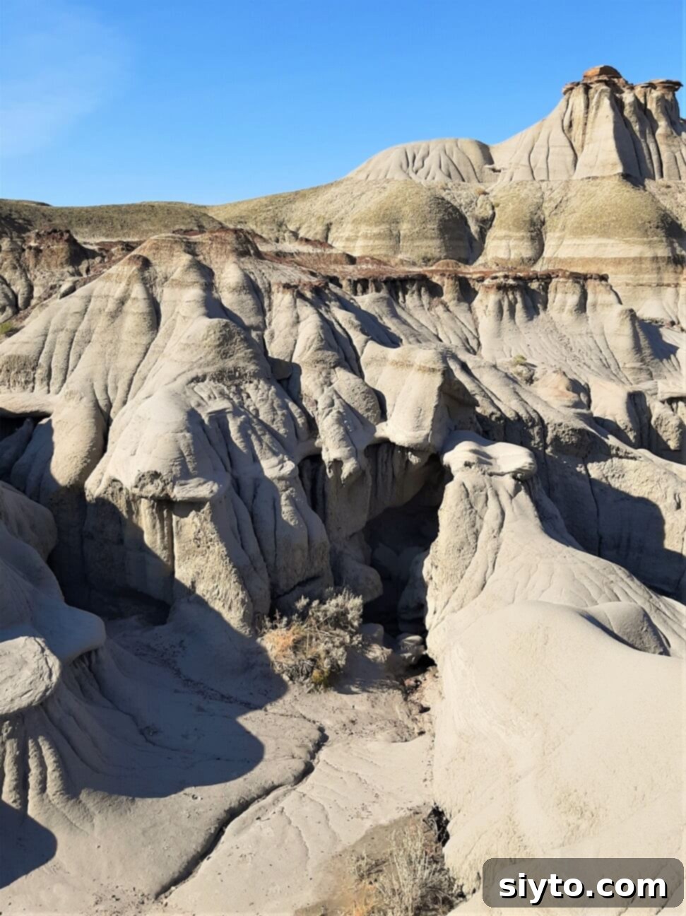 Intricately eroded land formations within Dinosaur Provincial Park, showcasing layers of rock and a rugged, ancient landscape.