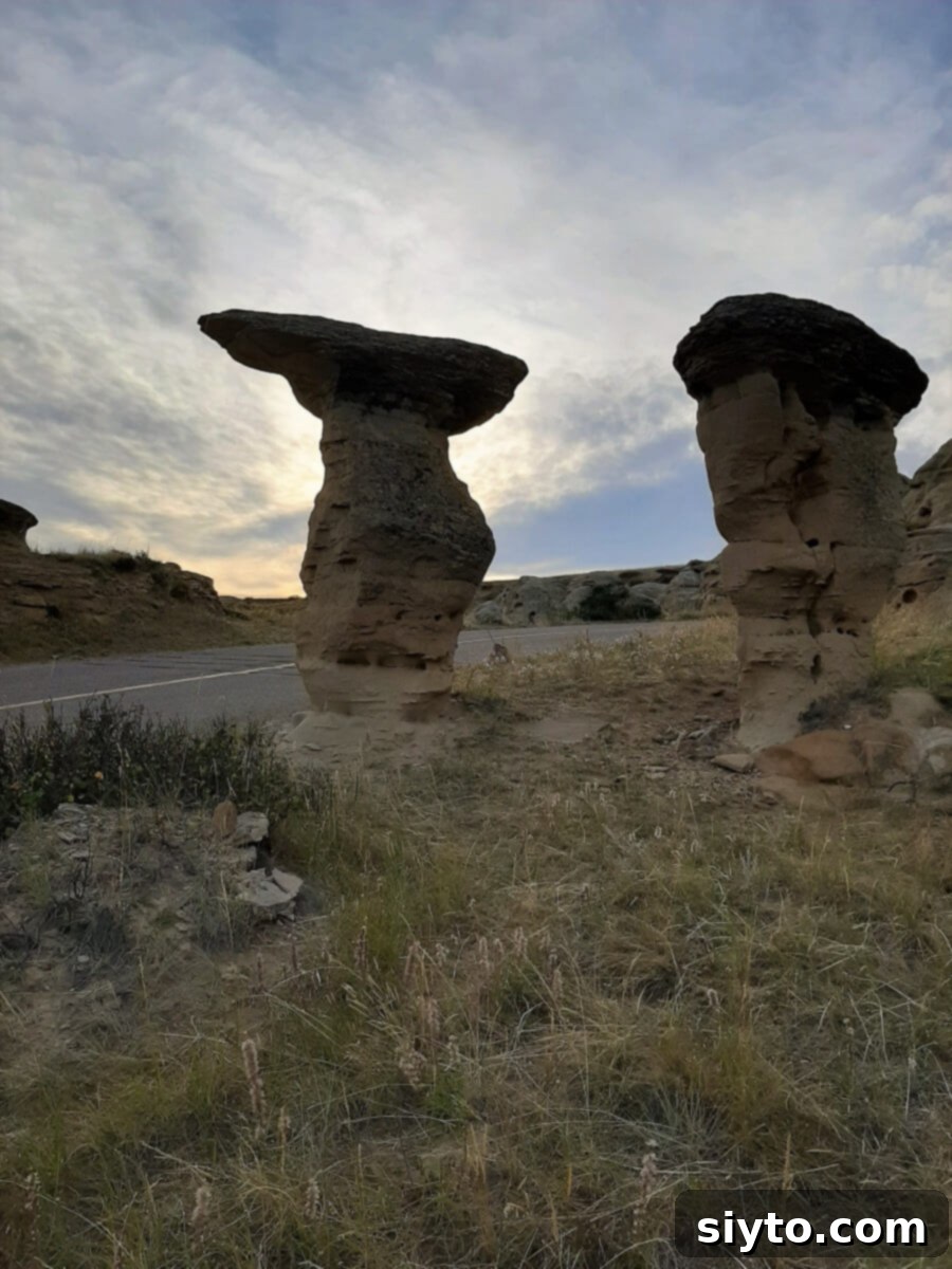 Two distinct hoodoo rock formations silhouetted against a dramatic sunset sky, creating a powerful and serene image at the end of the day.