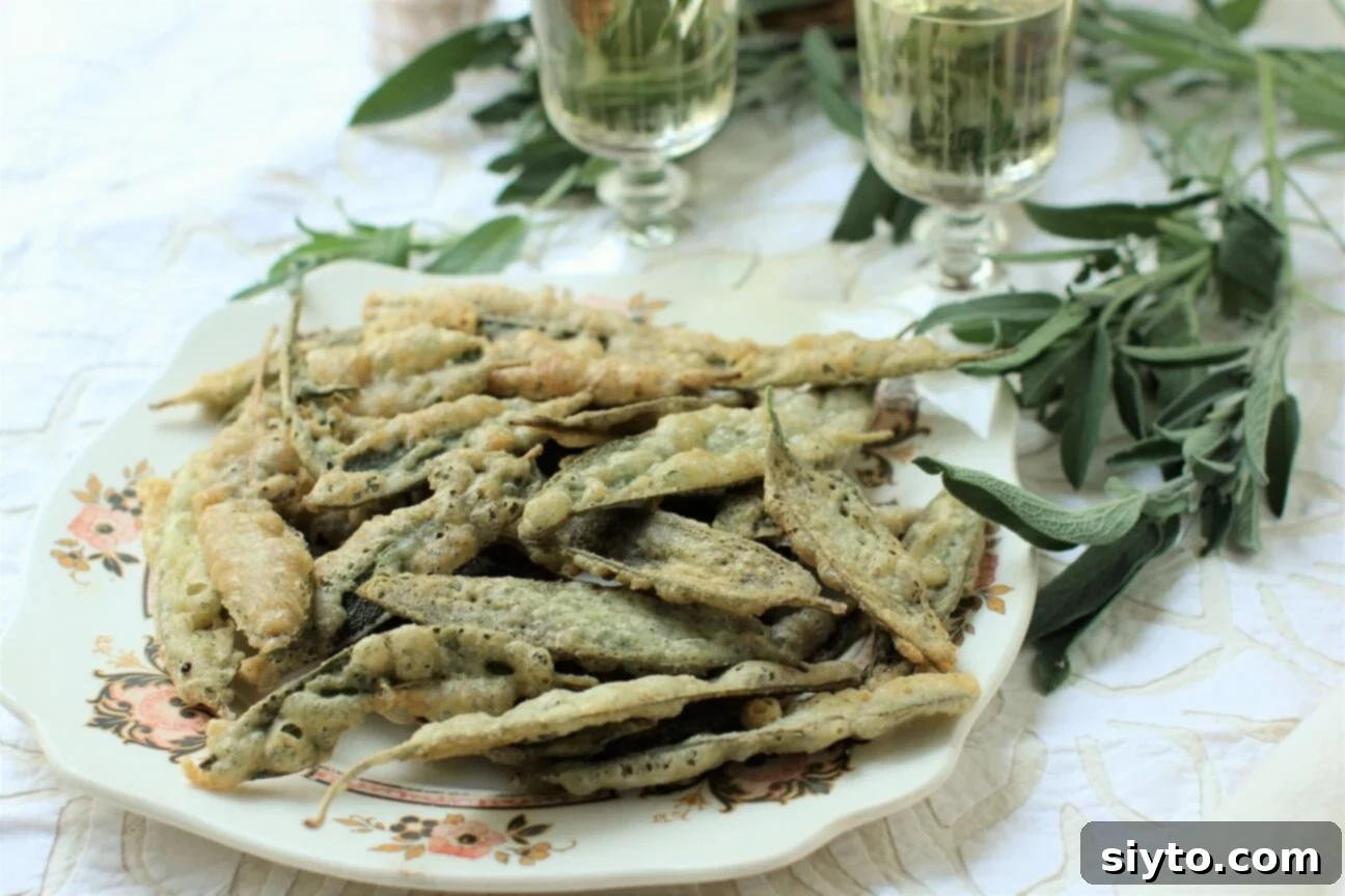 An elegant serving of crispy fried sage leaves on a pristine white plate, presented as a sophisticated appetizer.