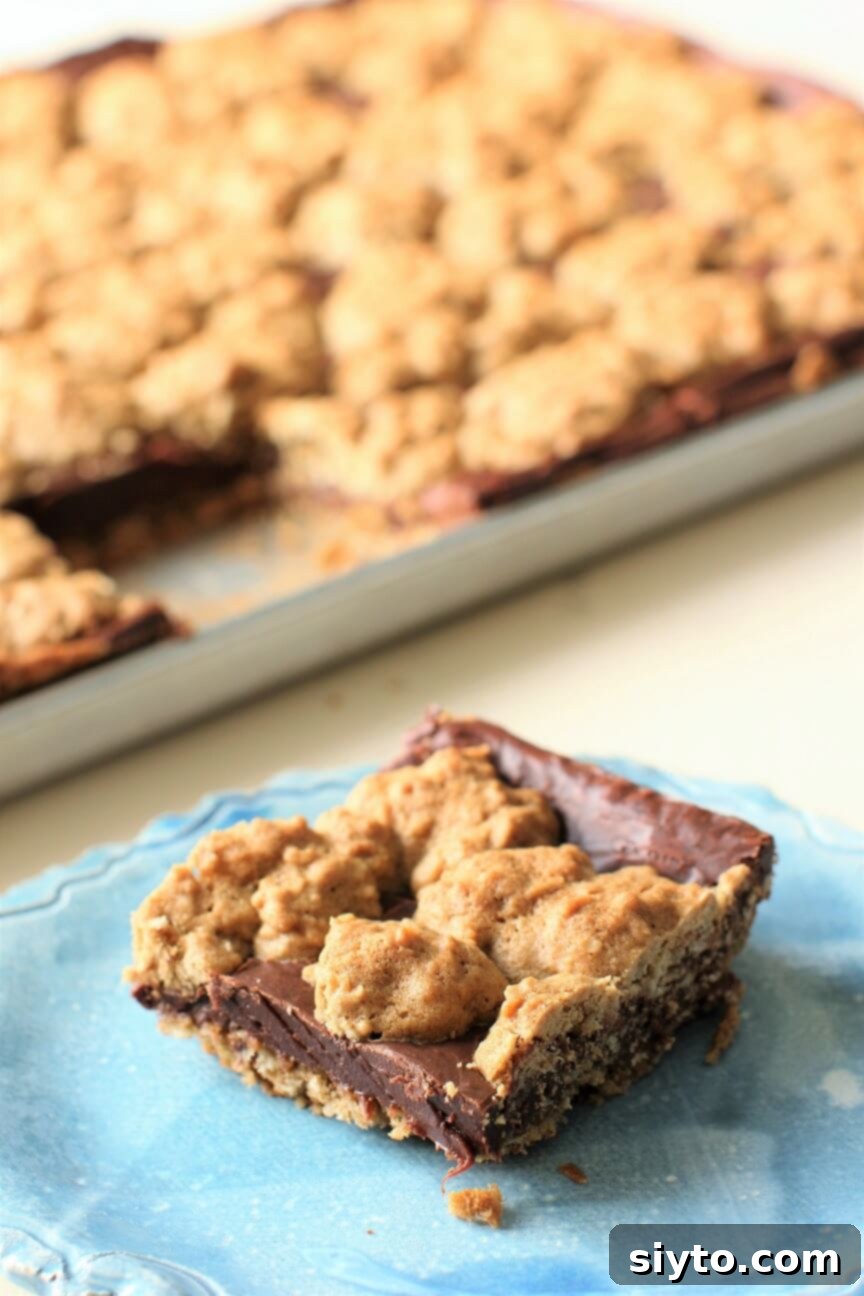 A delicious oat fudge bar on a blue plate, highlighting its layers