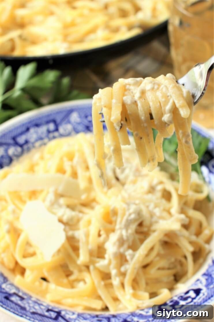 A forkful of creamy puffball fettuccine alfredo with tender mushroom pieces