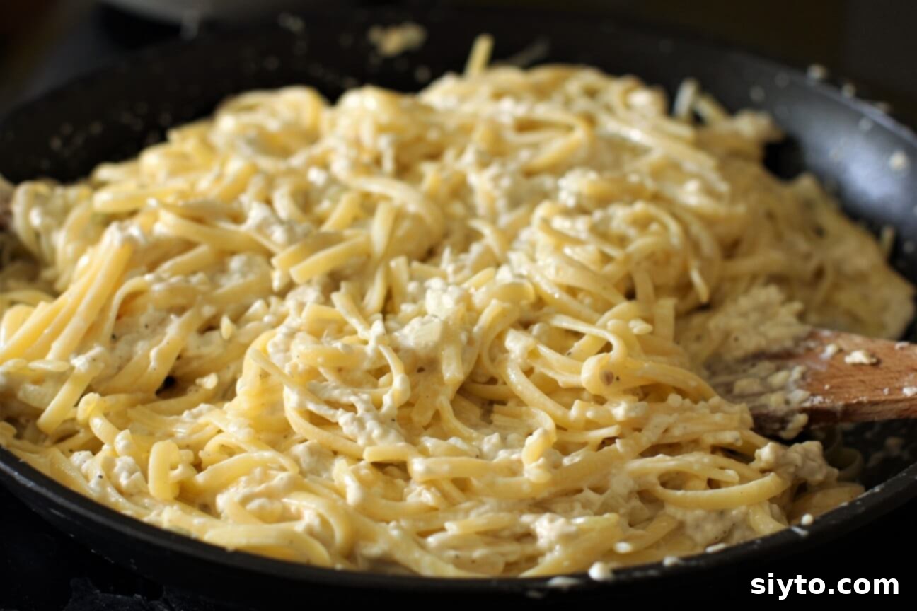 A close-up of a large skillet filled with creamy puffball fettuccine alfredo, ready to be served