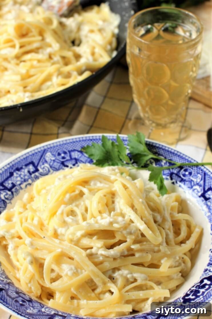 A serving of creamy puffball fettuccine alfredo in a white bowl, garnished with fresh herbs, ready for dinner