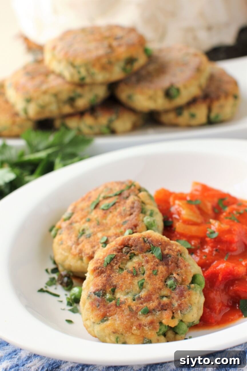 Two crispy puffball patties served alongside a rich tomato ratatouille, showcasing their golden-brown exterior and delicious potential.