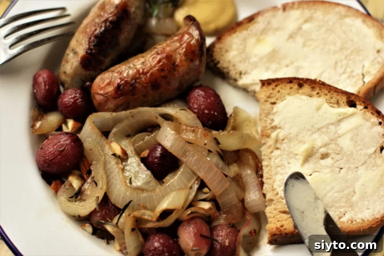 A delectable tangle of sweet onions, roasted grapes, and succulent bratwurst, served with buttered bread on a plate, ready to be enjoyed.