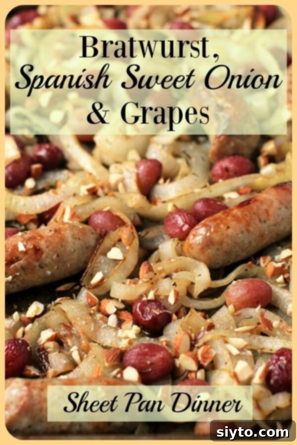A close-up view of the sheet pan, filled with the finished bratwurst bake, showcasing its golden-brown sausages, caramelized onions, and roasted grapes.