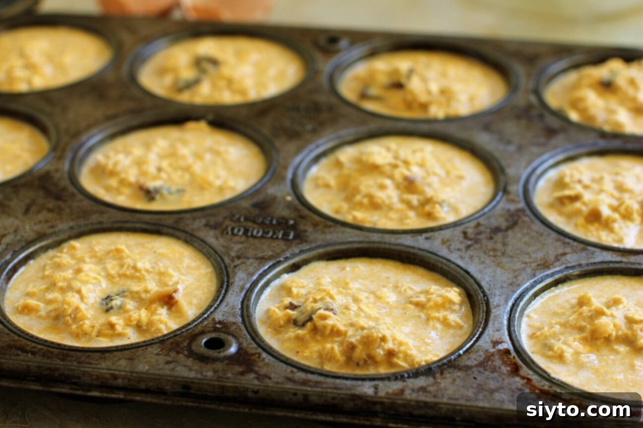 Handheld Harvest Pumpkin Oatmeal Muffins 5 muffin tins filled with pumpkin baked-oatmeal batter