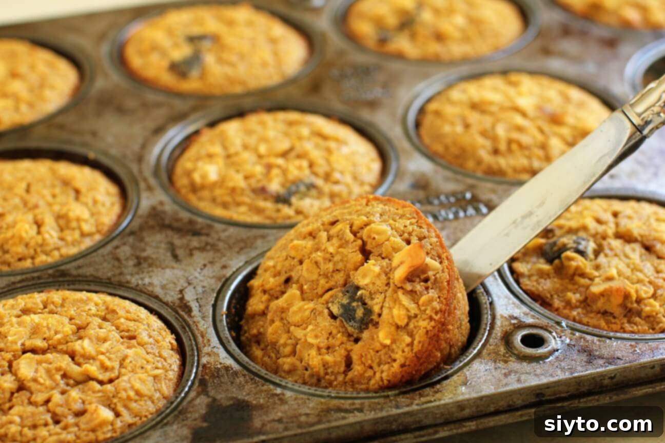 Handheld Harvest Pumpkin Oatmeal Muffins 6 removing a muffin from the tin