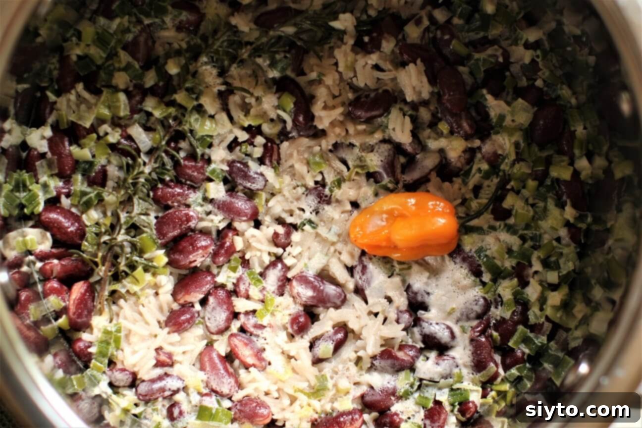 Freshly cooked Jamaican Rice and Peas in a large pot, with steam gently rising, just waiting for a final stir to fluff up.