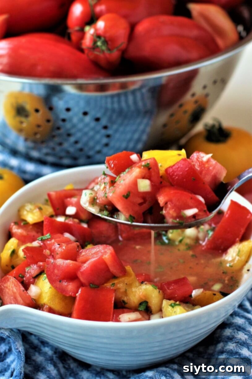 Classic German Tomato Salad 6 A slotted spoon lifting a spoonful of juicy German tomato salad, showing the vibrant tomatoes and dressing