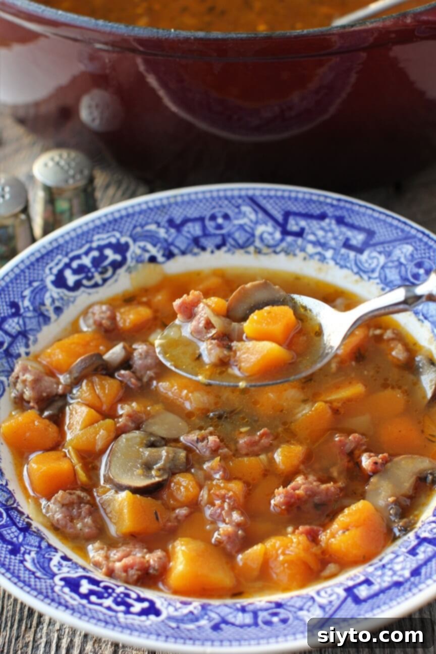 lifting a spoonful of sausage & butternut squash soup